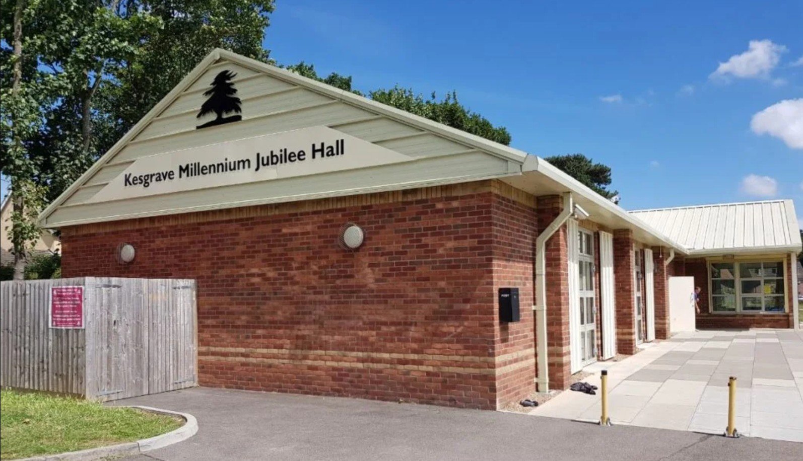 Exterior view of Kesgrave Millennium Jubilee Hall, a red-brick community building with cream roof and sign above the entrance reading “Kesgrave Millennium Jubilee Hall.”