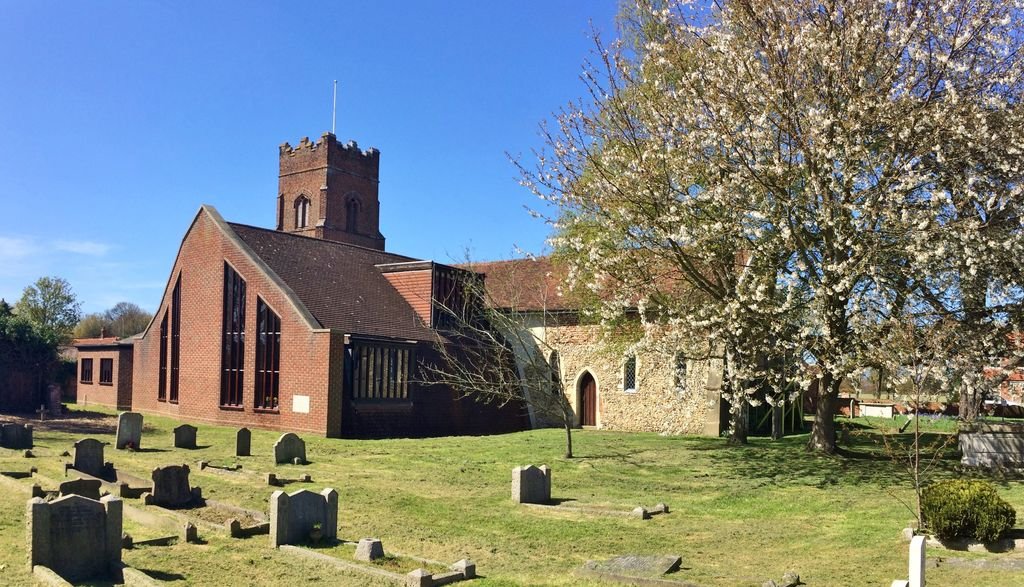 All Saints Church in Kesgrave with the adjoining Lawn Cemetery and blooming tree in springtime